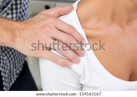 Man touching a woman\'s shoulder - bullying at work.