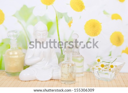 Massage oils and chamomile with Buddha figurine