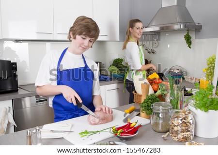 Mother cooking with her son in the kitchen