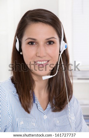Pretty brunette businesswoman wearing blue blouse with headset