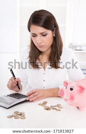 Woman is counting her money - sitting sad at desk and has lost her dreams