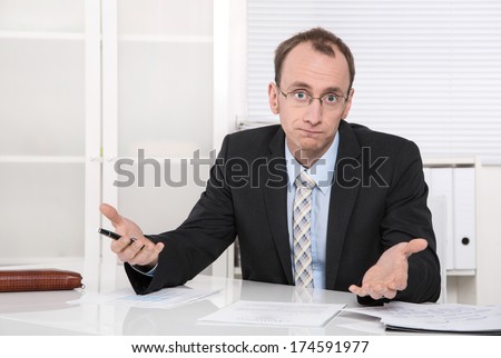 Questioningly bald engineer or specialist sitting at desk isolated on white.