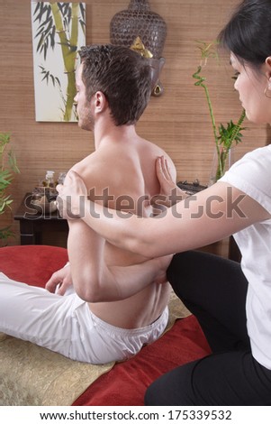Pressure point massage - man with female masseur in original thai massage