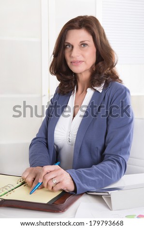 Portrait: Successful older business woman sitting in her office.