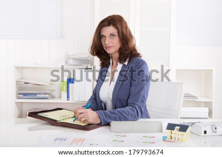 Portrait: Successful older business woman sitting in her office.