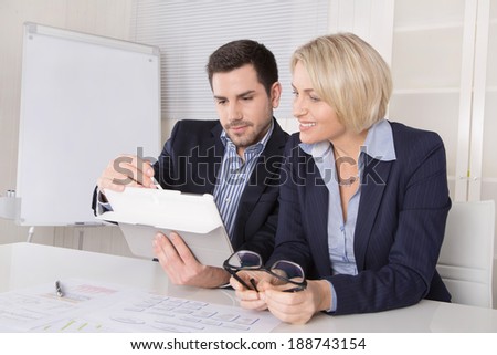 Senior female managing director with her assistant looking in a tablet.