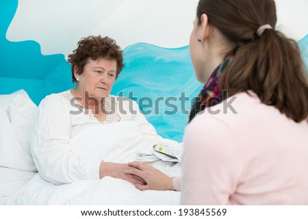 Illness: Older woman lying sick in the bed.