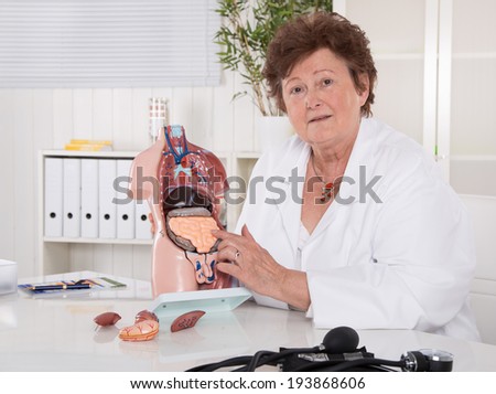 Senior female doctor explaining the human body with torso.