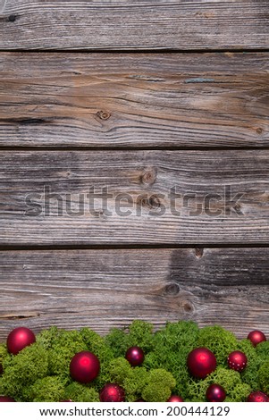 Old background of wood with red xmas balls and moss.