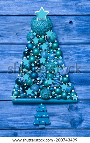 Blue and turquoise christmas tree of decoration balls on wood.