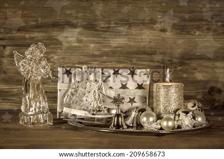 Silver and brown christmas decoration with present, angel and candle on wooden background.