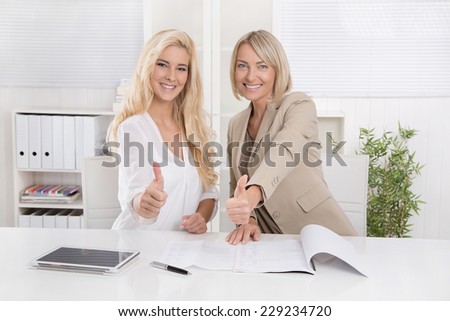 Two smiling blond businesswoman working in a team recommend financial products.