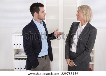 Business people in suit and dress talking together: small talk.