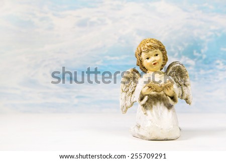 Christmas angel reading in a book telling a story on a background for a greeting card.