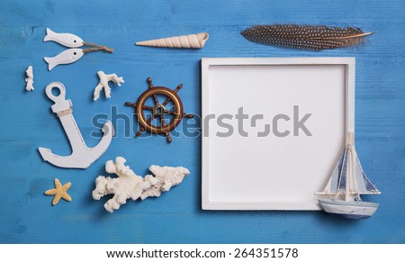 Nautical maritime decoration with anchor, sailboat and a white sign on a blue wooden background. Idea for summer vacation concepts.