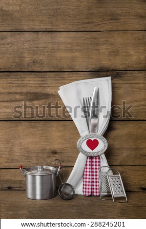 Menu card design for valentines, wedding or birthday party in red white checked with heart on wooden old background with cutlery.