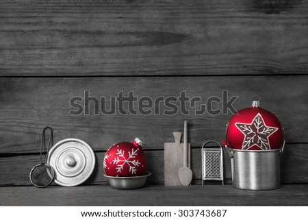 Christmas dinner. Wooden grey background with decoration of old silver tin miniatures for the kitchen and red xmas balls.