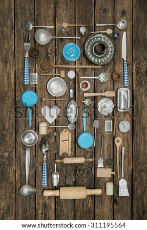 Vintage decoration of ancient kitchen equipment with cutlery and dishes on old wooden background for gastronomy.