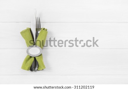 Wooden white background for a menu card with cutlery in red white checked colors for restaurants and gastronomy placards.