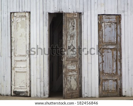 Three old wooden doors, one of them is open