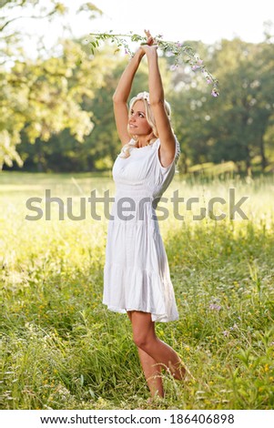 Attractive blonde in the field and holding flower in hand
