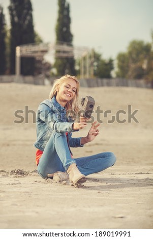young woman shooting selfie video with old analog camera