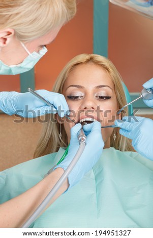 Dentist drilling tooth of young women