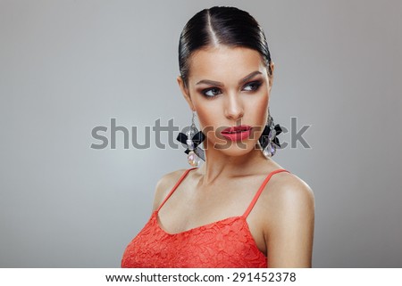 Attractive young woman with beautiful earrings posing in a studio