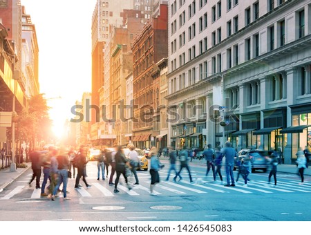 Crowds of people in motion across the busy intersection of 23rd Street and 5th Avenue in Midtown Manhattan, New York City NYC