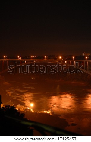 United States - Canada border bridge lit up at night by lights, at Niagara Falls
