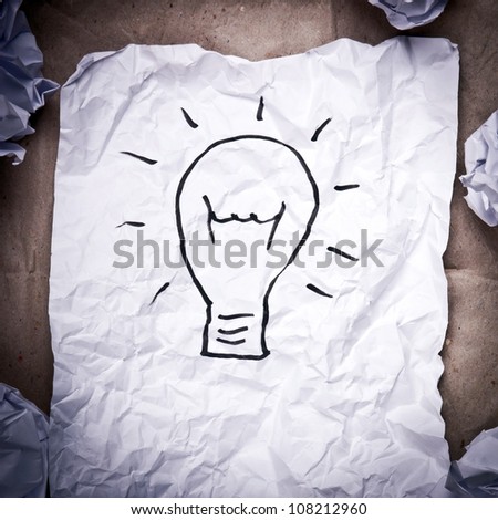 Crumpled paper with a lightbulb idea concept and crumpled paper attempts around it