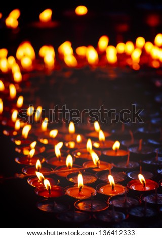 Tea light candles burning brightly in a dark room in Nepal