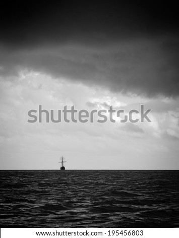 Classic sailing ship in the light of a huge storm