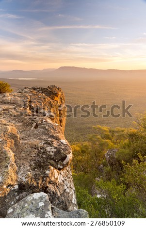 Mountain top views looking out over valley plain below in sunset light