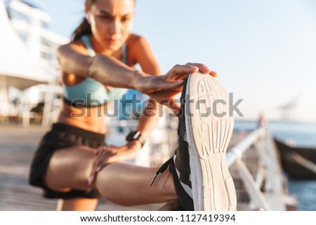 Similar – Image, Stock Photo Sportswoman stretching legs on stadium