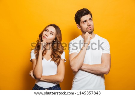 Image of happy young people man and woman in basic clothing thinking and touching chin while looking aside isolated over yellow background Stock foto © 