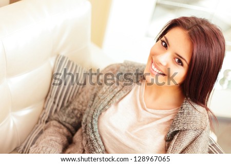 Closeup portrait of a Happy young beautiful woman relaxing on sofa at home