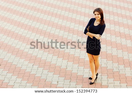 full-length shot of a happy beautiful businesswoman in formal dress outdoors