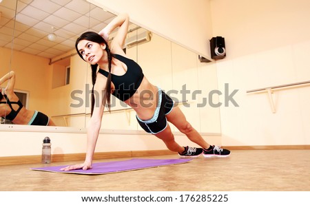 Young fit woman doing fitness exercises at gym