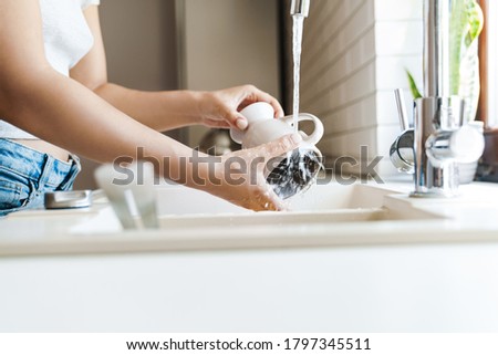 Close up of a young woman washing dishes at the sink at the kitchen Stock foto © 