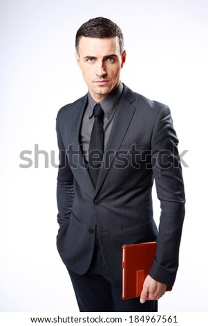 Confident businessman standing with tablet computer isolated on a white background