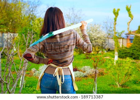 Back view portrait of a woman with shovel in garden