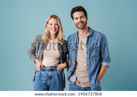 Young beautiful caucasian man and woman smiling and posing at camera isolated over blue background