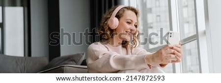 Similar – Image, Stock Photo Crop woman with headphones chatting on smartphone in evening town