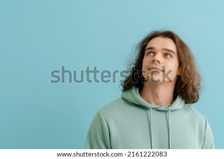 Similar – Image, Stock Photo Long haired young handsome man on a black background with a light illuminating his face, with a flirtatious expression for the camera showing a slight smile