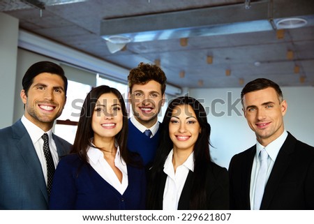 Group of a happy business people standing together in office