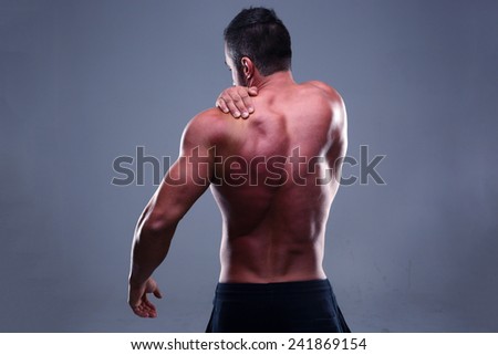 Portrait of a muscular mans back over gray background
