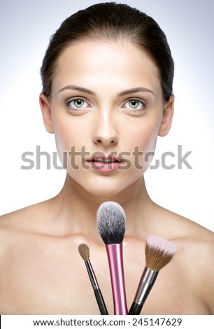 Closeup portrait of a beautiful woman holding brush for makeup