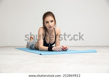 Portrait of a beautiful sports woman lying on the yoga mat