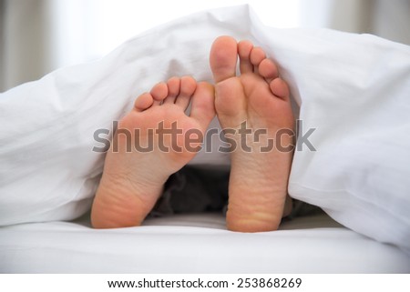 Feet of a young woman on the bed